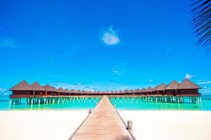Water bungalows and wooden jetty on tropical island in Indian Ocean photo