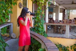 Young woman photographs the stunning view from cozy balcony photo