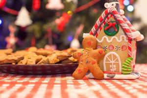 Cute gingerbread man and candy ginger house background Christmas tree lights photo