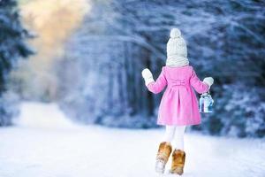 adorable chica con linterna y velas en invierno en la víspera de Navidad al aire libre foto