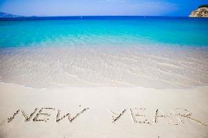 Happy New Year written in the white sand photo