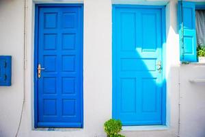 Traditional houses withe blue doors in the narrow streets of Mykonos, Greece. photo