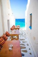 Benches with pillows in a typical greek bar in Mykonos with amazing sea view on Cyclades islands photo