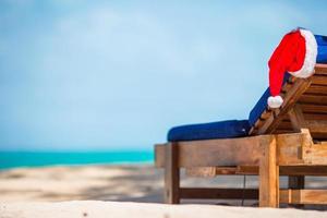 Santa Hat on beach lounger. Christmas vacation concept photo