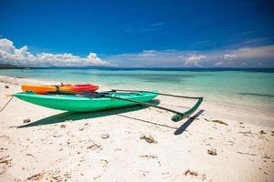 Small boat on the white sandy tropical beach photo