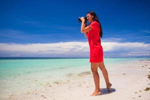 Young woman photographed beautiful sea on white sand beach photo