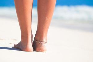 Women's beautiful smooth legs on white sand beach photo