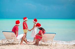 Happy family with two kids in Santa Hat on summer vacation photo