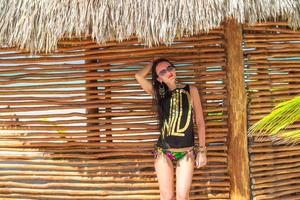 Young adorable woman in swimsuit and hat on the beach photo