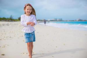 Adorable little girl at white beach during summer vacation photo