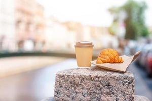 Traditional breakfast of coffee and fresh croissant outdoors photo
