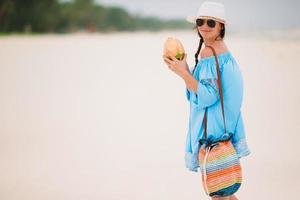 mujer joven bebiendo leche de coco durante las vacaciones tropicales foto