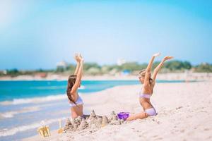 Beautiful mother and daughter on the beach enjoying summer vacation photo