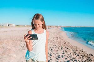 Adorable little girl at beach during summer vacation photo