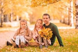 Family of dad and kids on beautiful autumn day in the park photo