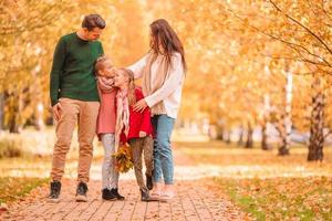 Portrait of happy family of four in autumn day photo