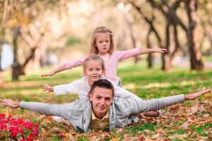 Family of dad and kids on beautiful autumn day in the park photo