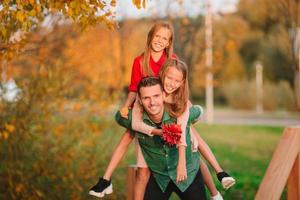 Family of dad and kids on beautiful autumn day in the park photo