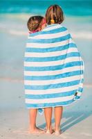 Adorable little girls wrapped in towel at tropical beach photo