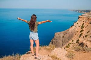 Tourist woman outdoor on edge of cliff seashore photo