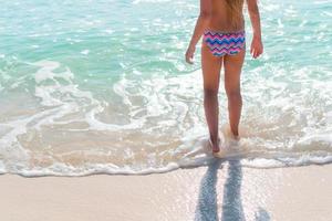 Closeup legs of little girl at shallow water photo