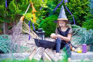 Halloween and adorable little girl dressed as a witch photo