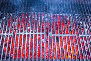 parrilla de hierro fundido negro vacía con carbones rojos calientes foto