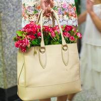 pequeñas flores rojas encantadoras en bolso de mujer de moda foto