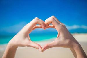 Heart made by hands background the turquoise ocean photo