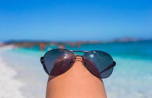 Close up of sunglasses on tropical beach photo
