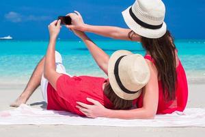 Happy couple taking a photo themselves on tropical beach