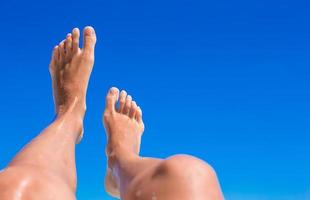 Closeup of female legs background of the turquoise sea photo