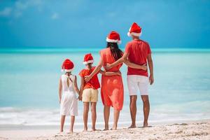 Happy family with two kids in Santa Hat on summer vacation photo
