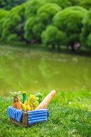 Picnic setting with white wine, pears, fruits, bread photo