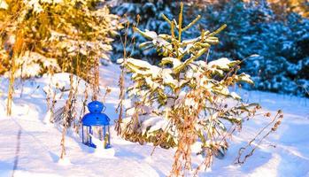 hermosa linterna azul con una vela en la nieve blanca al aire libre foto