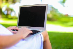 Young woman with laptop during summer vacation photo