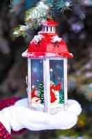 Beautiful red vintage Christmas lantern on warm mittens photo