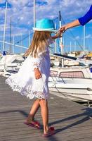 una niña adorable se divierte en un puerto el día de verano foto