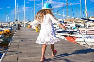 una niña adorable se divierte en un puerto el día de verano foto