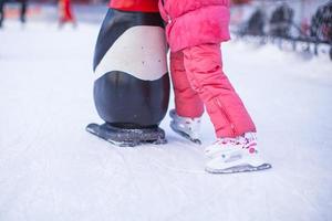 Little skater's legs standing on winter ice rink photo