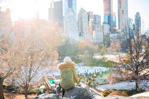 Adorable girl with view of ice-rink in Central Park on Manhattan in New York City photo