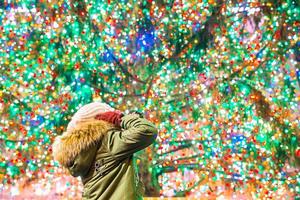 Happy girl on the background of the Rockefeller Christmas tree in New York photo