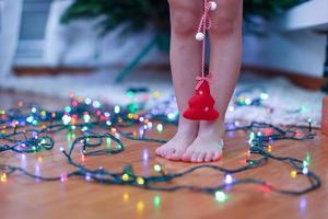 Little red tree in the hands of charming cute girl at bright lights background photo