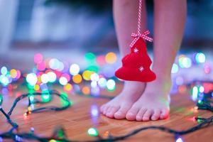 arbolito rojo en manos de una chica encantadora y linda con fondo de luces brillantes foto