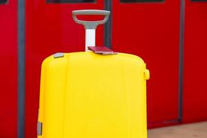 Primer plano de pasaportes rojos en equipaje amarillo en la estación de tren foto