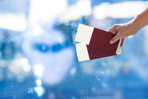 Pasaportes de primer plano y tarjeta de embarque en el avión de fondo interior del aeropuerto foto