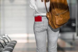 mujer joven feliz con billete de avión y pasaportes en el aeropuerto esperando el embarque foto