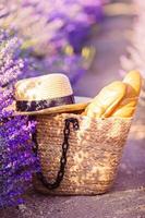 bolsa de paja de primer plano y sombrero en el campo de lavanda foto