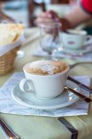 capuchino delicioso y sabroso para el desayuno en el café foto