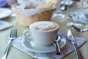 capuchino delicioso y sabroso para el desayuno en el café foto